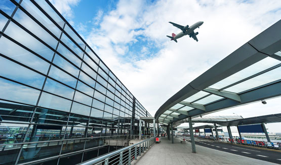 Airplane flying over airport terminal