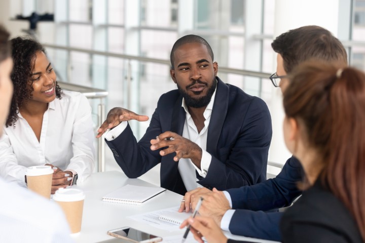 Male student discusses career options with four other students at a table