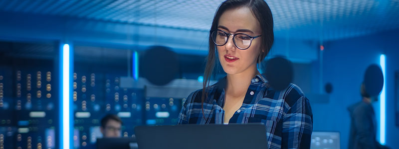 A female student in front of a computer in a data center.