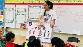 Teacher displaying a cardboard to students.