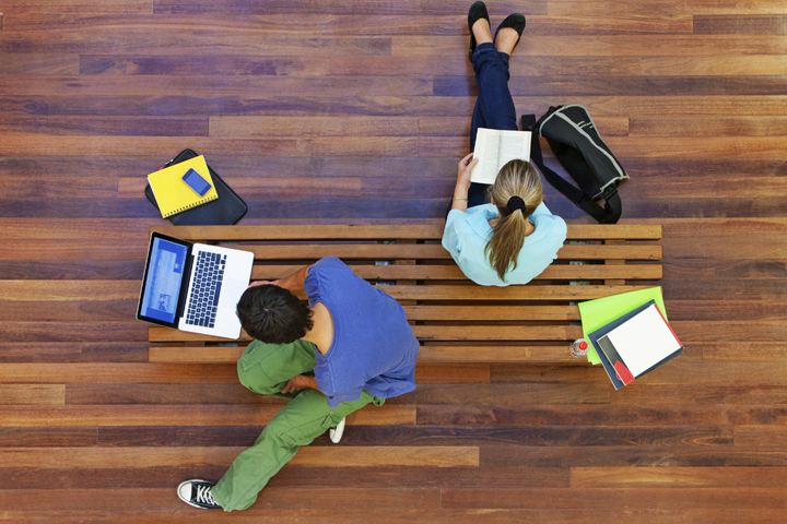 students sitting on a bench studying