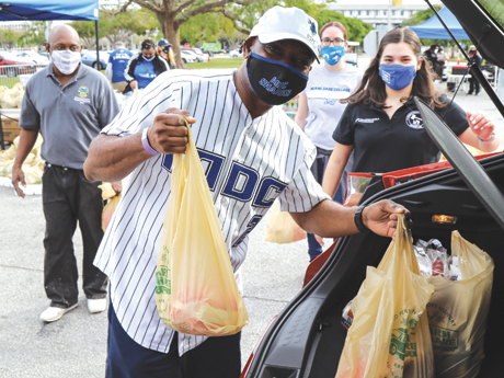 MDC staff distributing bags of food for community